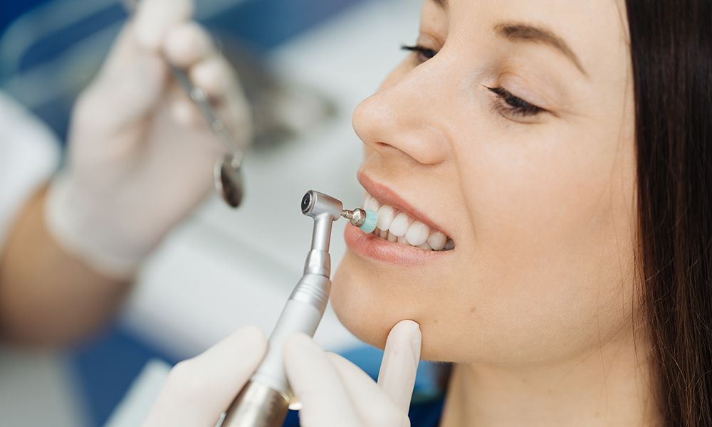 Chica en la silla del dentista durante un procedimiento de escalado dental.